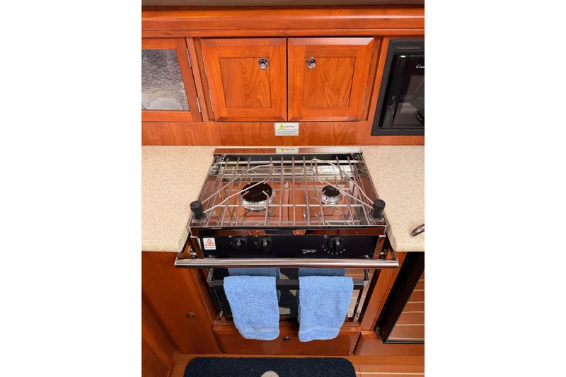 Slide: The Image of Galley kitchen in 2009 Hunter 38 yacht with stove and wooden cabinetry. - 25