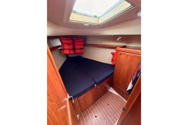 Slide: The Image of 2009 Hunter 38 yacht cabin with skylight, wooden interior, and life jackets. - 39