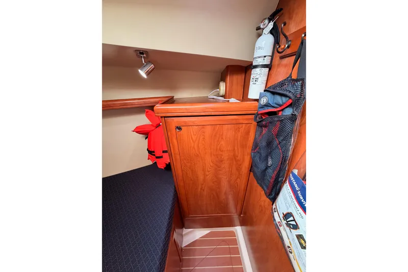 Slide: The Image of 2009 Hunter 38 yacht interior with wooden cabinetry, fire extinguisher, and life jackets. - 41