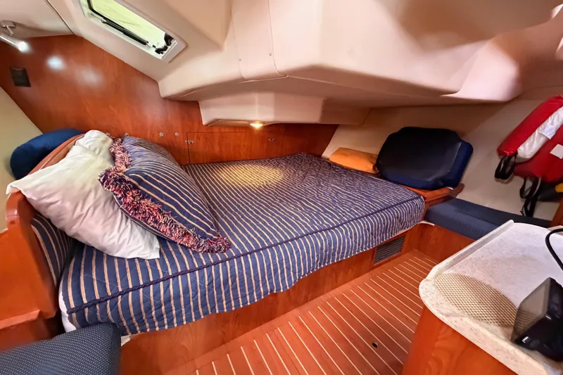 Slide: The Image of Cozy cabin interior of 2009 Hunter 38 sailboat with striped bedding and wood finish. - 47