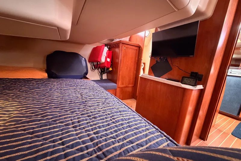 Slide: The Image of Cozy cabin interior of 2009 Hunter 38 yacht with bed, TV, and wooden furnishings. - 49