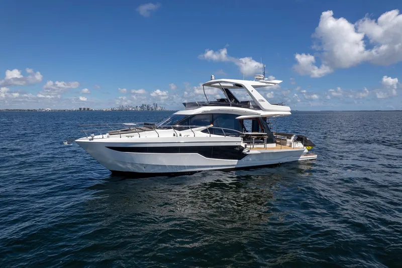 Slide: The Image of 2021 Galeon 500 Fly yacht cruising on open water under a clear blue sky. - 13