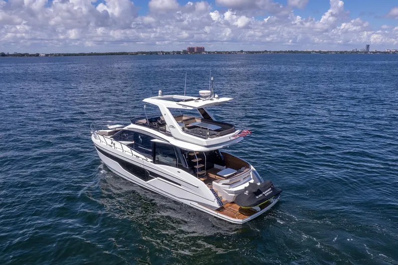 Slide: The Image of 2021 Galeon 500 Fly yacht cruising on open water under a partly cloudy sky. - 18