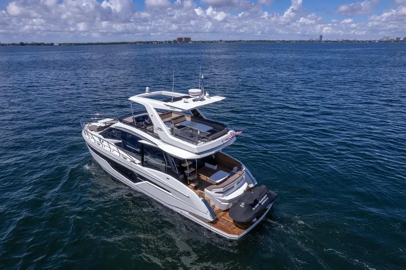 Slide: The Image of 2021 Galeon 500 Fly yacht cruising on open water under a partly cloudy sky. - 19