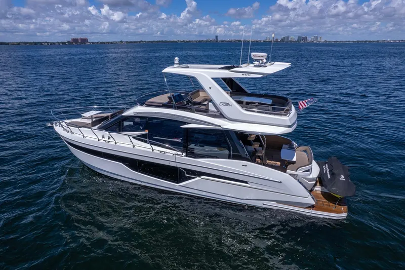 Slide: The Image of 2021 Galeon 500 Fly yacht cruising on open water under a clear blue sky. - 20