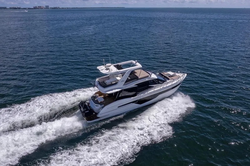 Slide: The Image of 2021 Galeon 500 Fly yacht cruising on open sea, creating white wake trails. - 3