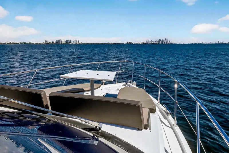 Slide: The Image of 2021 Galeon 500 Fly yacht cruising with city skyline in the background. - 31