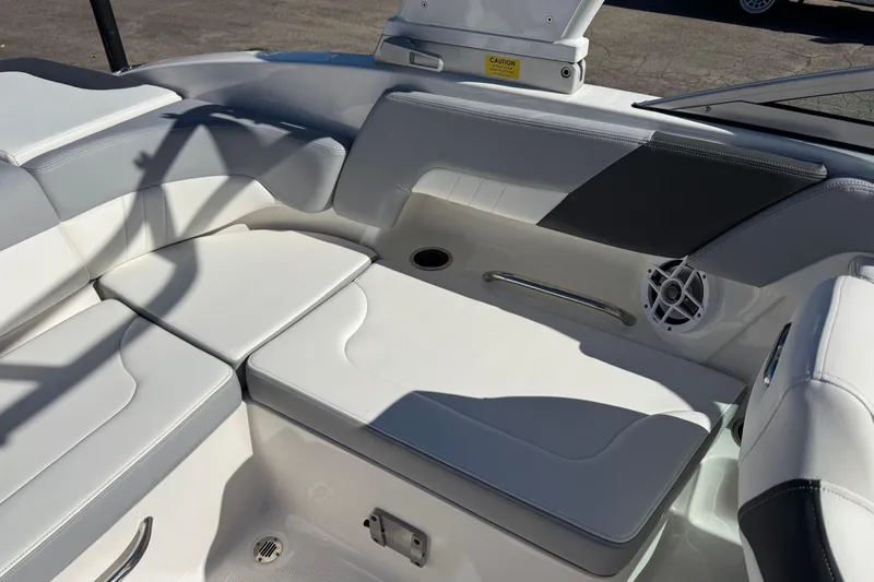 Slide: The Image of 2024 Chaparral 23 SSi OB boat interior with white cushioned seating and speaker. - 14