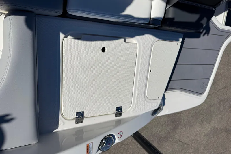 Slide: The Image of 2024 Chaparral 23 SSi OB boat deck with storage compartment and seating area. - 17