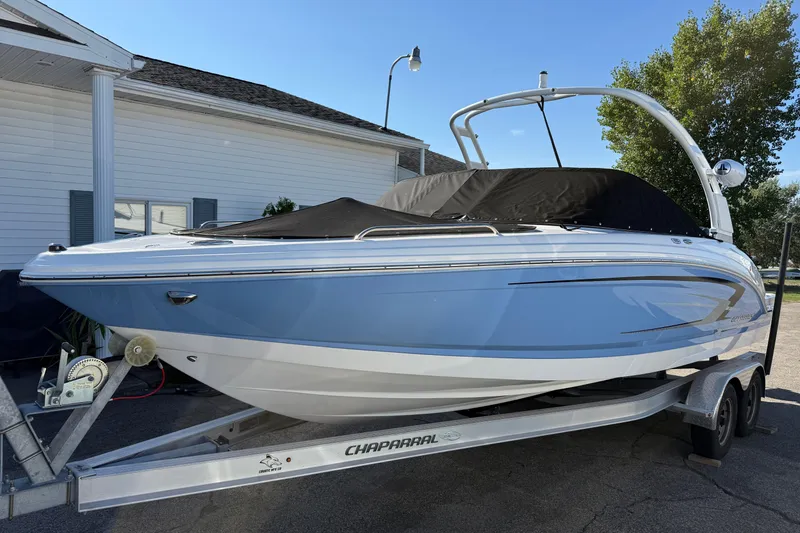 Slide: The Image of 2024 Chaparral 23 SSi OB boat on trailer, covered and parked outdoors. - 2