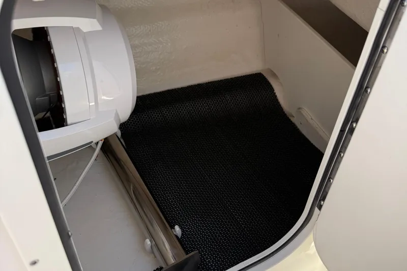 Slide: The Image of 2024 Chaparral 23 SSi OB boat interior storage compartment with black mat. - 7