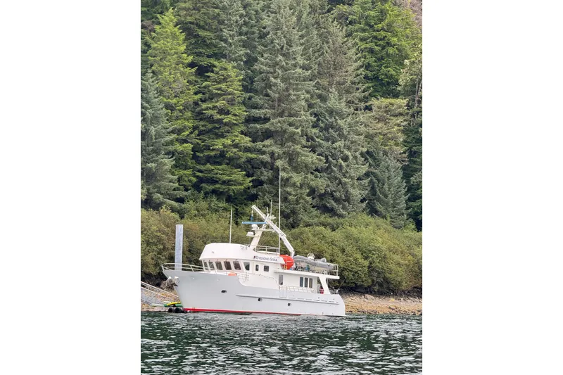 The Image of Cape Horn 2003 Trawler docked by lush forest shoreline. - 0