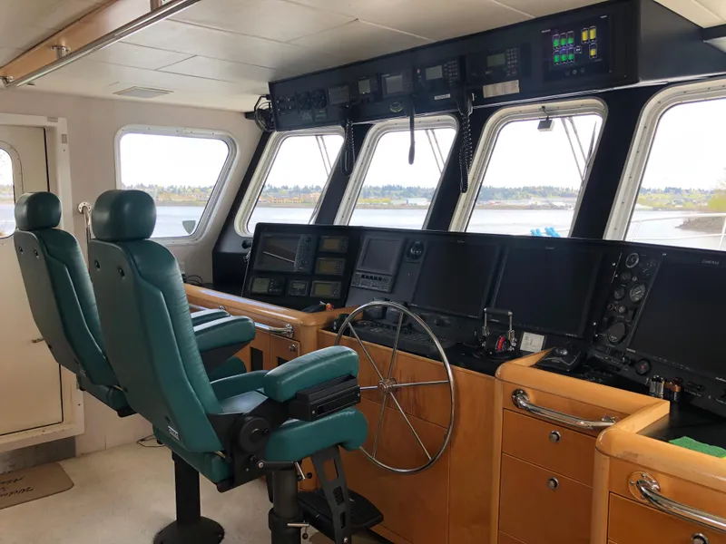 Slide: The Image of 2003 Cape Horn Trawler cockpit with navigation equipment and green captain chairs. - 11