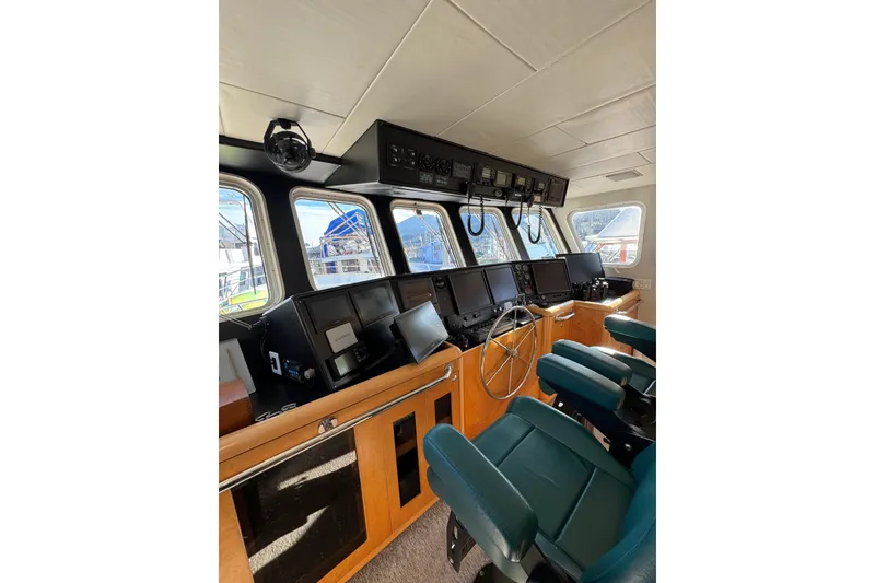 Slide: The Image of 2003 Cape Horn Trawler helm with navigation equipment and green captain chairs. - 12