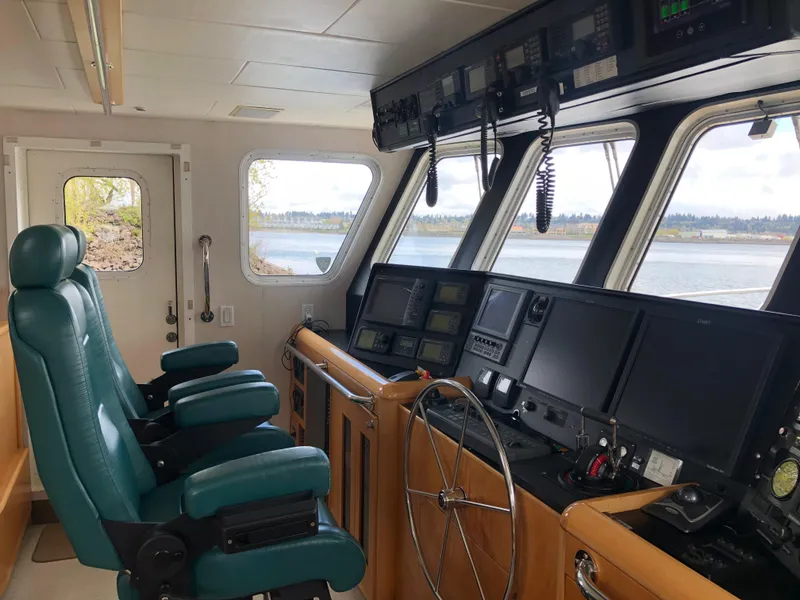 Slide: The Image of 2003 Cape Horn Trawler cockpit with navigation equipment and green captain chairs. - 13