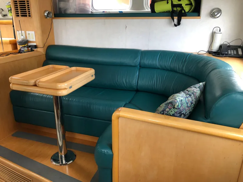 Slide: The Image of Luxurious interior of a 2003 Cape Horn Trawler with teal seating and wooden table. - 15