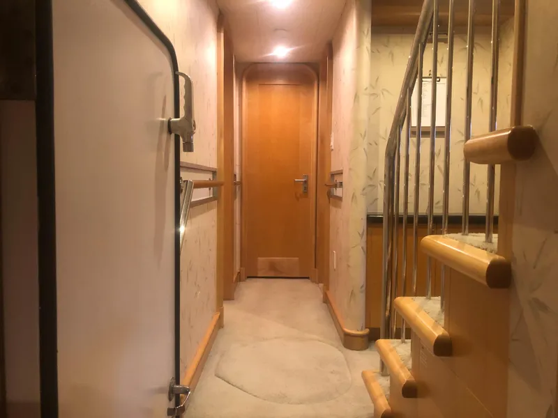 Slide: The Image of 2003 Cape Horn Trawler interior hallway with wooden stairs and door. - 24
