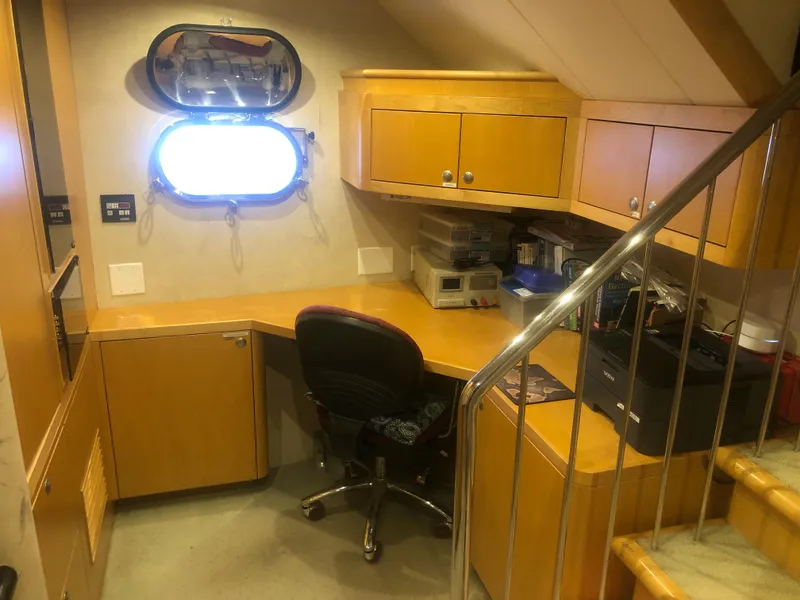 Slide: The Image of Office space inside a 2003 Cape Horn Trawler, featuring wooden cabinetry and a porthole window. - 28
