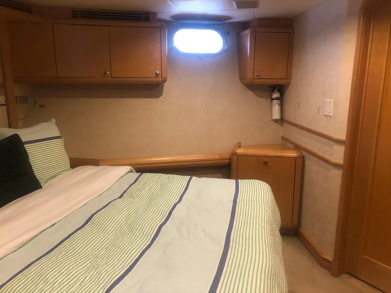 Slide: The Image of Cozy bedroom interior of 2003 Cape Horn Trawler with wood cabinets and striped bedding. - 39