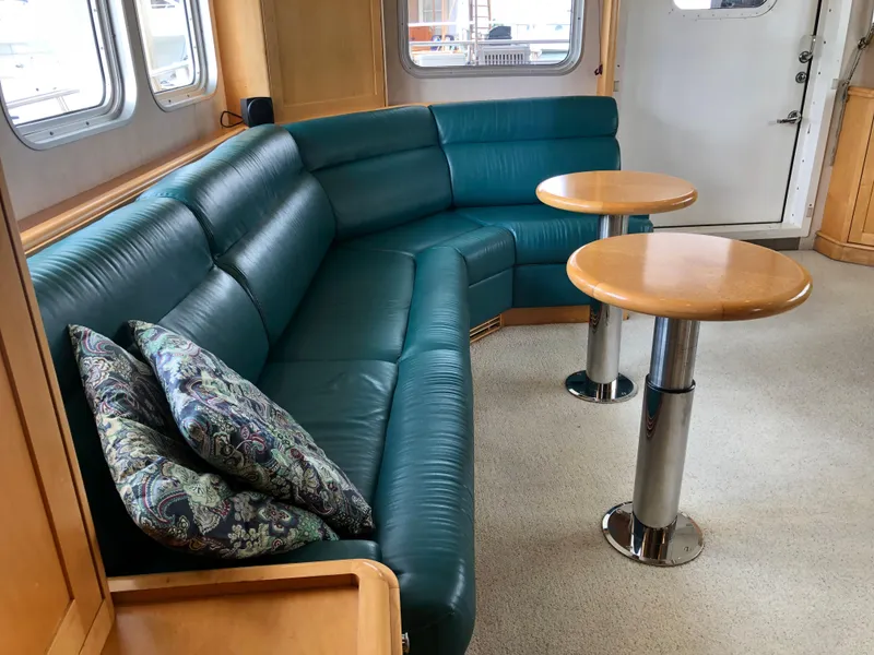 Slide: The Image of Luxurious 2003 Cape Horn Trawler interior with green leather seating and wooden tables. - 4