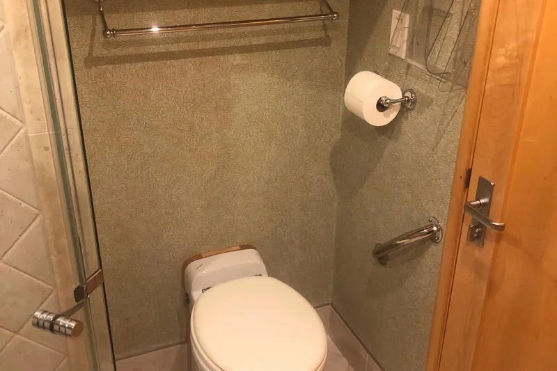 Slide: The Image of Compact bathroom in a 2003 Cape Horn Trawler, featuring a toilet and towel rack. - 45