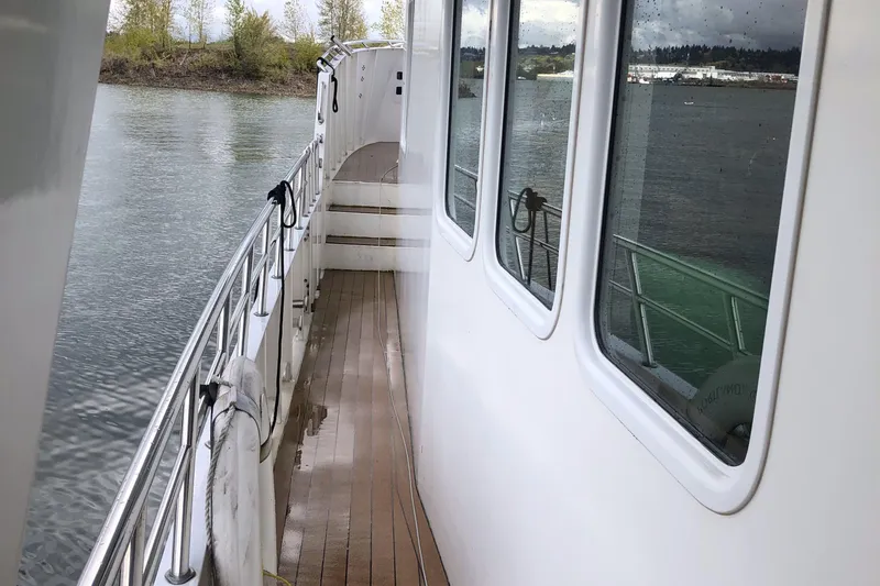 Slide: The Image of 2003 Cape Horn Trawler deck with railing, overlooking calm water and shoreline. - 51