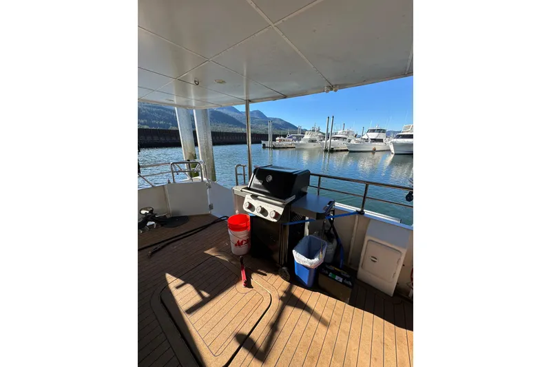 Slide: The Image of 2003 Cape Horn Trawler deck with grill, docked at marina, scenic mountain view. - 53