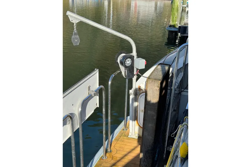 Slide: The Image of 2003 Cape Horn Trawler deck with railing and pulley system by the water. - 54