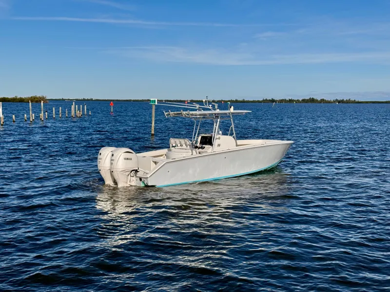 Slide: The Image of 2008 Jupiter 30 boat with twin Yamaha engines on calm water under clear blue sky. - 2