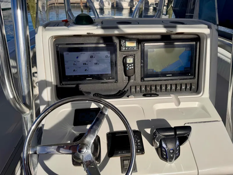 Slide: The Image of Boat dashboard with dual Garmin screens, steering wheel, and controls on a 2008 Jupiter 30. - 22