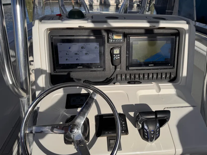 Slide: The Image of Boat dashboard with steering wheel, dual Garmin displays, and controls on a 2008 Jupiter 30. - 23