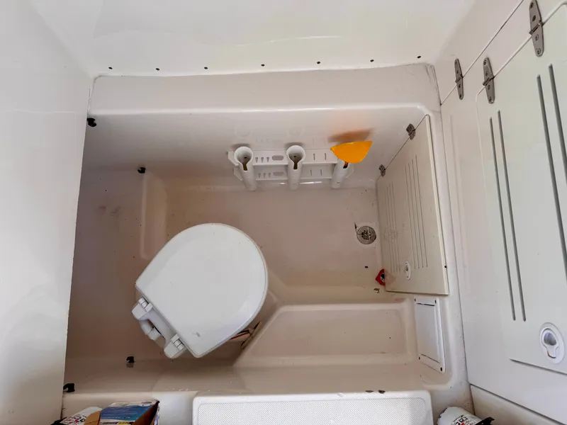 Slide: The Image of Boat interior with a compact toilet, storage compartments, and a drain, Jupiter 30 model, 2008. - 34