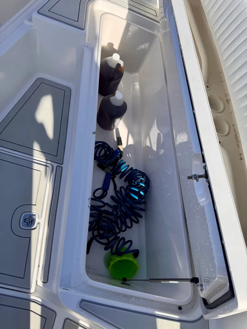 Slide: The Image of Storage compartment on a 2008 Jupiter 30 boat with coiled hose and bottles. - 36