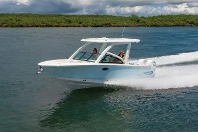 Slide: The Image of 2026 Robalo R257 Dual Console boat cruising on a serene waterway. - 22
