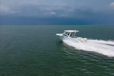 Slide: The Image of 2026 Robalo R257 Dual Console boat cruising on open water under cloudy skies. - 23