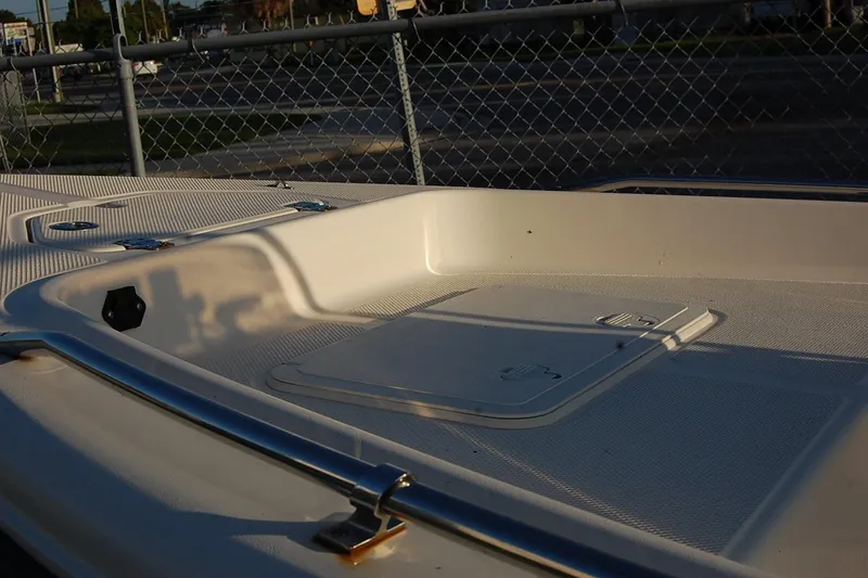 Slide: The Image of 2006 KEYWEST 152 boat deck with storage compartment, metal railing, and textured surface. - 3