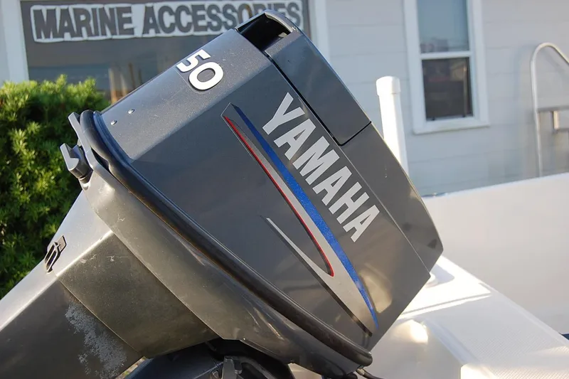 Slide: The Image of Yamaha 50 outboard motor on a 2006 KEYWEST 152 boat near marine accessories shop. - 9