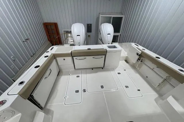 Slide: The Image of 2021 Pursuit OS 355 Offshore boat interior with seating and dual engines in storage. - 12