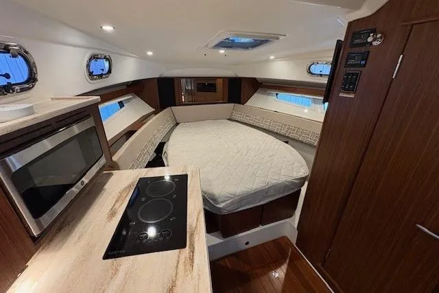Slide: The Image of 2021 Pursuit OS 355 Offshore cabin interior with TV and control panel. - 25