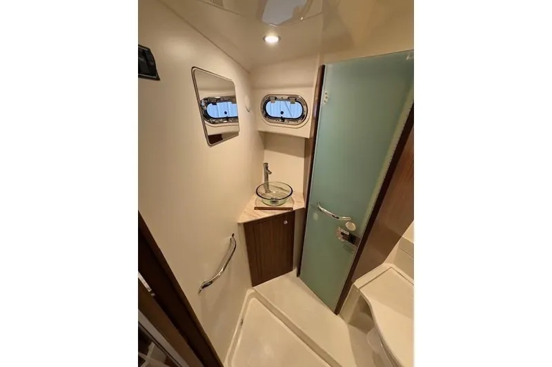 Slide: The Image of 2021 Pursuit OS 355 Offshore boat bathroom with modern fixtures and frosted glass door. - 28