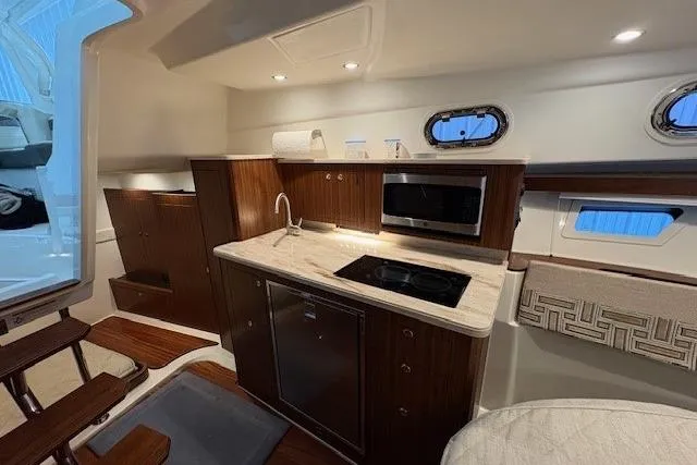 Slide: The Image of 2021 Pursuit OS 355 Offshore cabin with elegant seating and wooden table. - 32