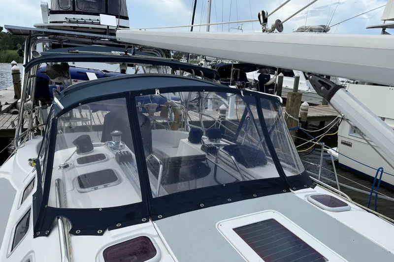 Slide: The Image of 2004 Hunter 386 sailboat docked, featuring a blue canopy and sleek deck design. - 10
