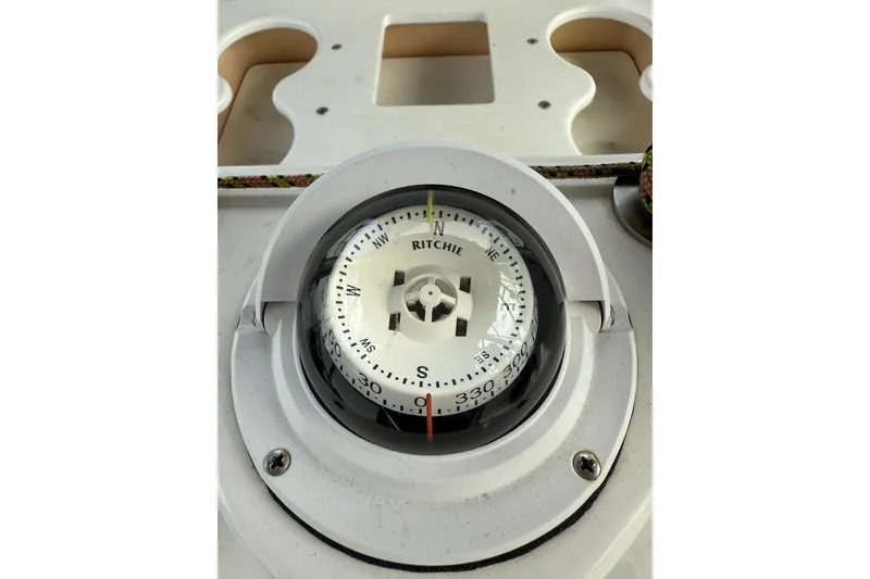 Slide: The Image of Compass on a 2004 Hunter 386 sailboat, displaying cardinal directions. - 13