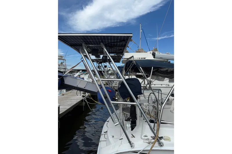 Slide: The Image of 2004 Hunter 386 sailboat with solar panels docked at marina under blue sky. - 14
