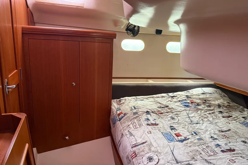 Slide: The Image of Cozy cabin interior of 2004 Hunter 386 sailboat with nautical-themed bedding. - 19