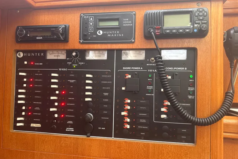 Slide: The Image of Electrical control panel of a 2004 Hunter 386 sailboat with various switches and displays. - 28