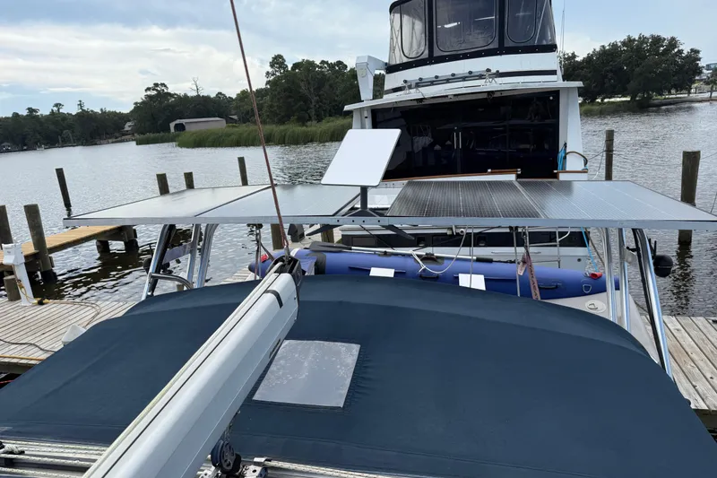 Slide: The Image of Hunter 386 sailboat with solar panels docked by a serene lake, 2004 model. - 4