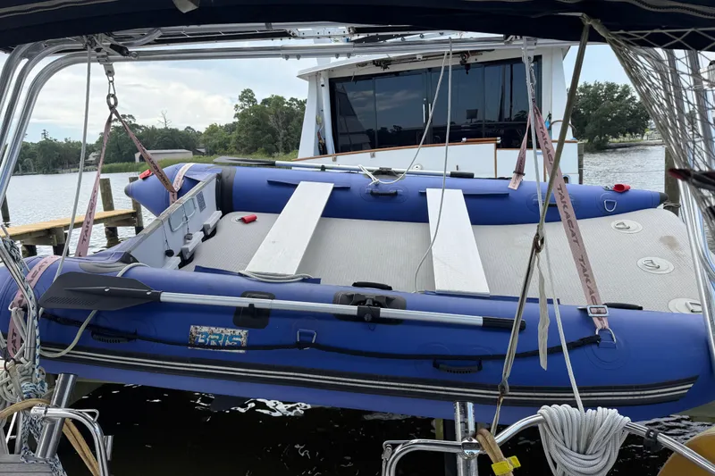 Slide: The Image of Inflatable boat on a Hunter 386 sailboat, docked by a scenic river. - 8