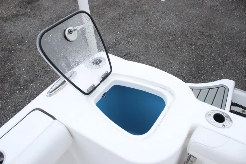 Slide: The Image of Open storage compartment on 2026 Tidewater 232 LXF boat, featuring a blue interior. - 17