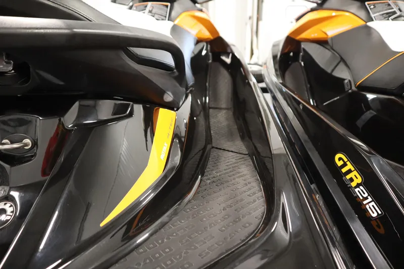 Slide: The Image of 2012 Sea-Doo GTR 215 jet ski, close-up view of sleek black and orange design. - 16